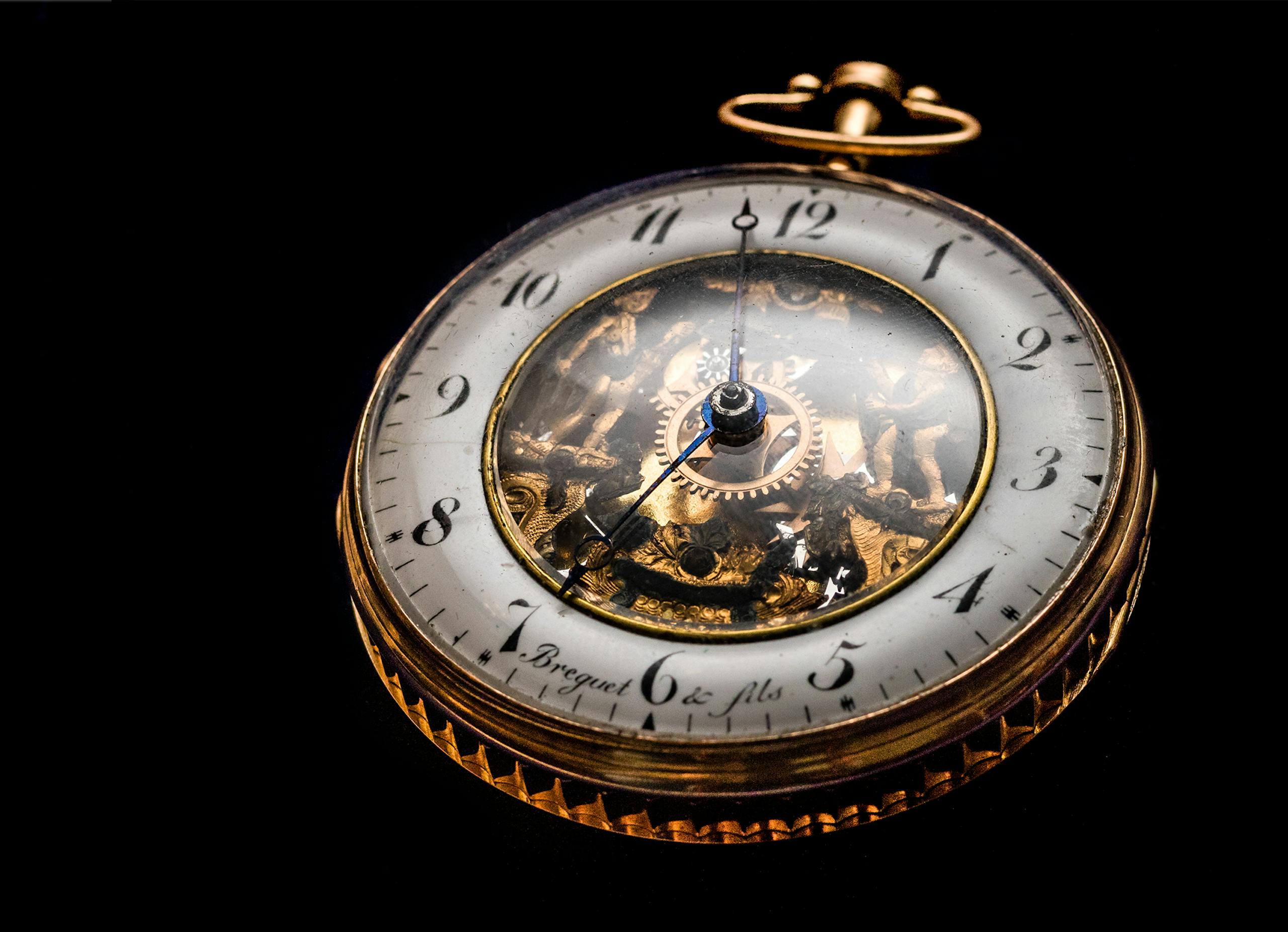 Close-up of a vintage gold pocket watch showcasing intricate gears on a black backdrop.